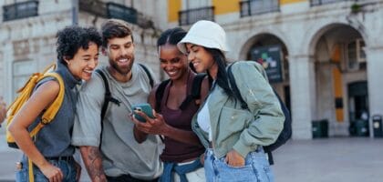 Young travelers checking phone for allergy information while exploring city