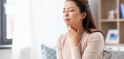 Woman experiencing throat discomfort from allergic symptoms