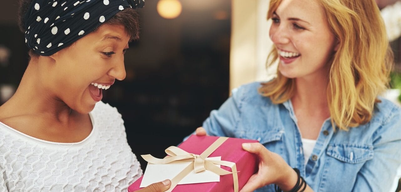 Woman receiving allergy-friendly gift from friend during holidays